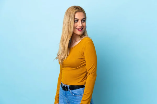 Ung Uruguayansk Blond Kvinna Över Isolerad Blå Bakgrund Ser Sida — Stockfoto