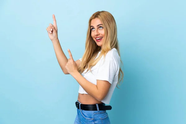 Mladá Uruguayská Blondýnka Přes Izolované Modré Pozadí Ukazující Ukazováčkem Skvělý — Stock fotografie
