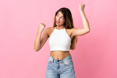 Pembe arka planda izole edilmiş beyaz bir kadın zaferi kutluyor.