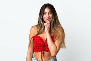 Beyaz arka planda izole edilmiş beyaz bir kadın sessiz bir jest işareti gösteriyor. Parmağını ağzına sokuyor.