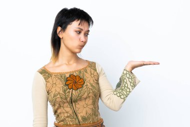 İzole edilmiş beyaz arkaplan üzerindeki genç Uruguaylı kız telif alanını şüpheyle tutuyor