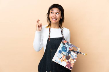 Genç bir sanatçı arka planda bir palet tutuyor ve şans diliyor.