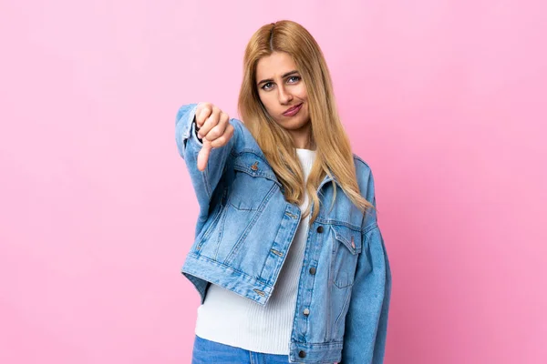 Молодая Уругвайская Блондинка Изолированном Розовом Фоне Показывает Большой Палец Вниз — стоковое фото