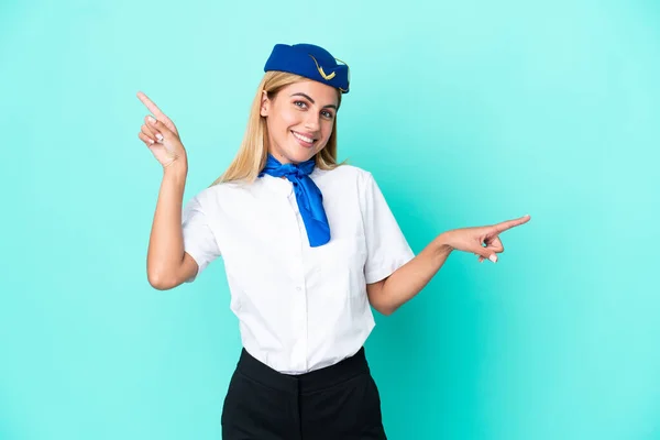 飛行機スチュワーデスウルグアイの女性は ラテン語と幸せな指を指して青色の背景に隔離 — ストック写真