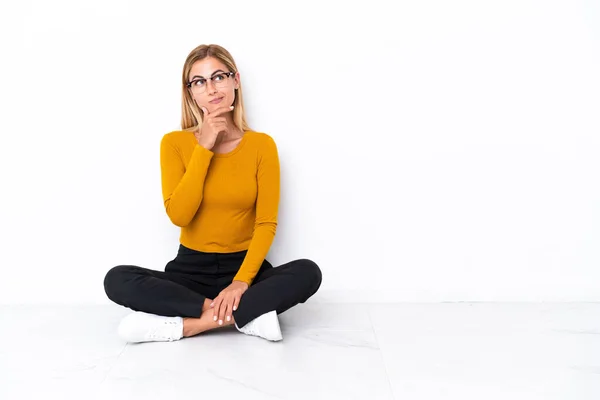 Blond Uruguayaans Meisje Zitten Vloer Met Twijfels Met Verwarrende Gezicht — Stockfoto