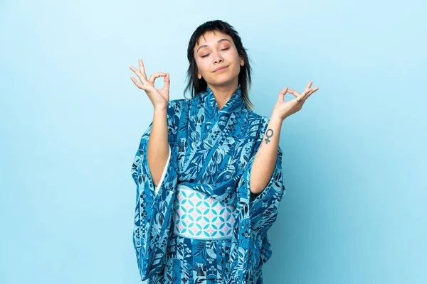 Mujer Joven Con Kimono Sobre Fondo Azul Aislado Pose Zen —  Fotos de Stock