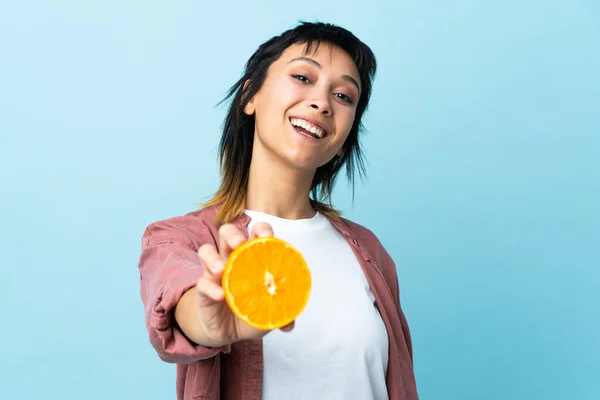 Ung Uruguayansk Kvinna Över Isolerad Blå Bakgrund Håller Orange — Stockfoto