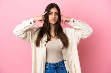 Pembe arka planda soyutlanmış beyaz bir kadın. Şüpheleri ve düşünceleri var.