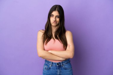 Mor arka planda izole edilmiş genç beyaz kadın üzgün hissediyor.