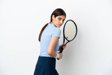 Beyaz arka planda tenis oynayan beyaz tenli genç kadın.