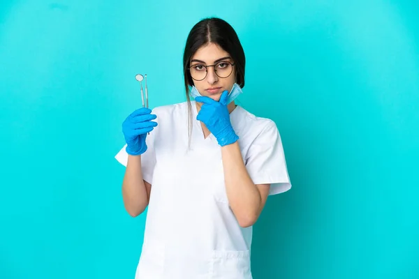 Junge Kaukasische Zahnärztin Mit Werkzeugen Auf Blauem Hintergrund — Stockfoto