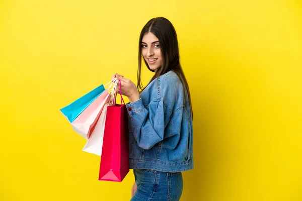 Junge Kaukasische Frau Isoliert Auf Blauem Hintergrund Mit Einkaufstaschen Und — Stockfoto
