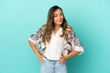 Soyutlanmış mavi arka planı olan genç bir kadın.