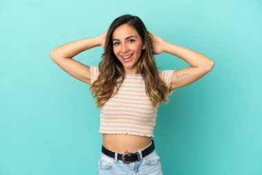 Genç bir kadın mavi arka planda gülüyor.