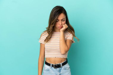 İzole edilmiş mavi arka planı olan genç bir kadın.