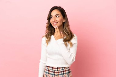 Genç kadın izole arka plan üzerinde gülümseyerek yukarı bakıyor