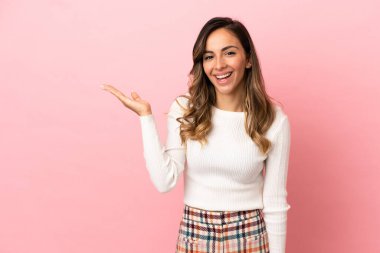 Arka planda izole edilmiş genç bir kadın, bir ilan vermek için avucunun içinde hayali bir alan tutuyor.