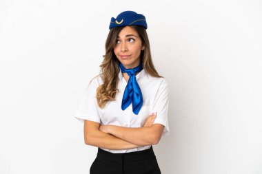 İzole edilmiş beyaz arka planda uçak hostesi omuzlarını kaldırırken şüpheyle hareket ediyor.