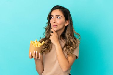 Kızarmış cipsleri izole edilmiş arka planda tutan genç bir kadın.