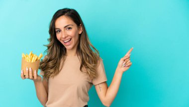 Kızarmış cipsleri izole edilmiş arka planda tutan genç bir kadın.