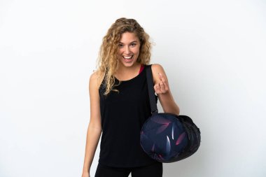 Spor çantalı genç bir kadın beyaz arka planda izole edilmiş para hareketi yapıyor.