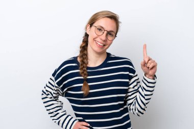 Beyaz arka planda izole edilmiş genç beyaz kadın en iyinin işareti olarak parmağını kaldırıyor ve gösteriyor.