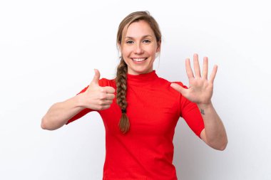 Beyaz arka planda izole edilmiş beyaz tenli genç kadın parmaklarıyla altısını sayıyor.