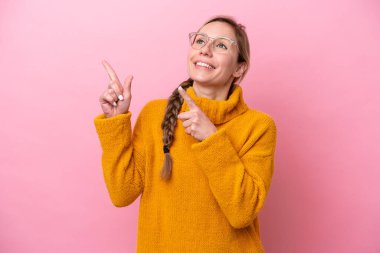 Pembe arka planda izole edilmiş genç beyaz kadın işaret parmağıyla işaret etmek harika bir fikir.