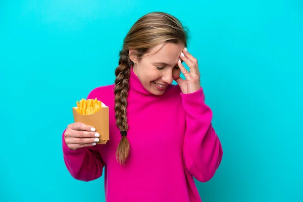 Young Caucasian Woman Holding Fried Chips Isolated Blue Background Laughing — Stock Fotó