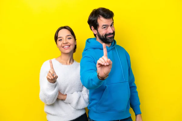 Young Caucasian Couple Isolated Yellow Background Showing Lifting Finger — Stock fotografie