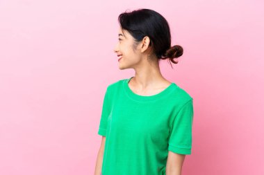 Pembe arka planda izole edilmiş genç Vietnamlı kadın.