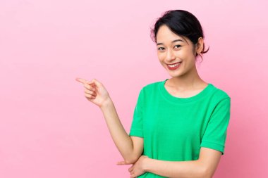 Pembe arka planda izole edilmiş genç Vietnamlı bir kadın.