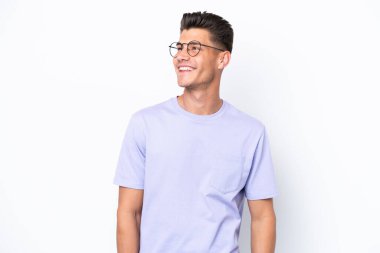 Beyaz arka planda izole edilmiş genç beyaz adam yukarı bakarken bir fikir düşünüyor.