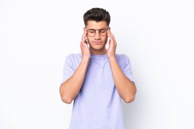 Beyaz arka planda başı ağrıyan genç beyaz bir adam.