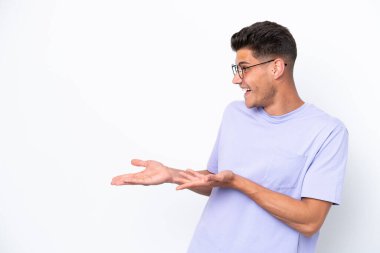 Beyaz arka planda beyaz tenli genç bir adam sürpriz bir ifadeyle yan yana bakarken...