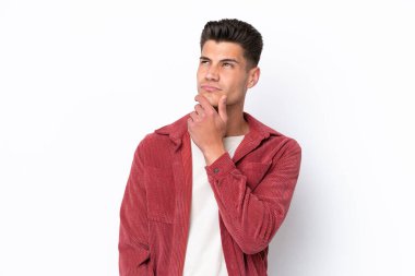 Beyaz arka planda soyutlanmış genç beyaz bir adamın şüpheleri var.