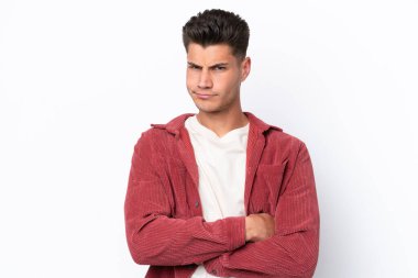 Beyaz arka planda izole edilmiş, mutsuz bir ifadeyle genç beyaz bir adam.