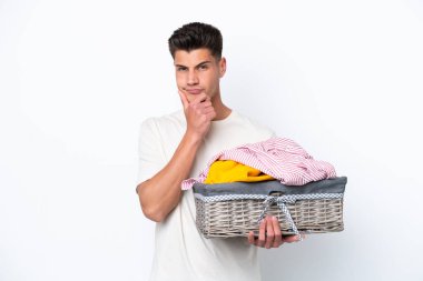Beyaz arka planda çamaşır sepetini tutan genç beyaz bir adam...