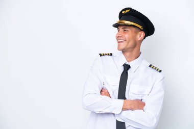 Kafkasyalı uçak pilotu beyaz arka planda izole edilmiş mutlu ve gülümsüyor.