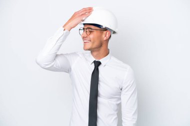 Miğferli ve elinde beyaz arka planda izole edilmiş planları olan genç bir beyaz mimar bir şeyi fark etti ve çözüme niyetlendi.