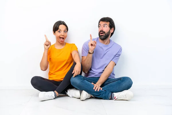 Young Caucasian Couple Sitting Floor Isolated White Background Intending Realizes — Stockfoto