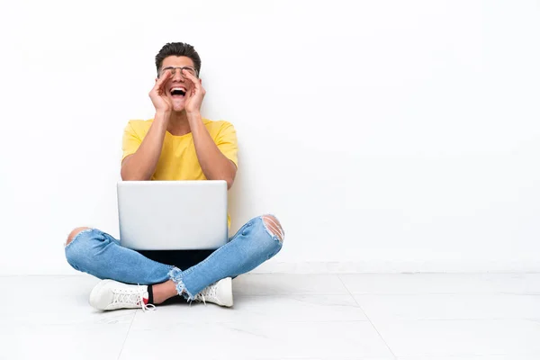 Jovem Sentado Chão Isolado Fundo Branco Gritando Anunciando Algo — Fotografia de Stock