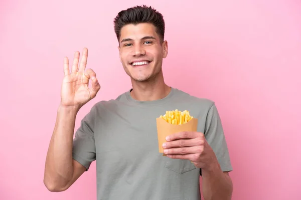 Jonge Blanke Man Met Gebakken Chips Geïsoleerd Roze Achtergrond Tonen — Stockfoto