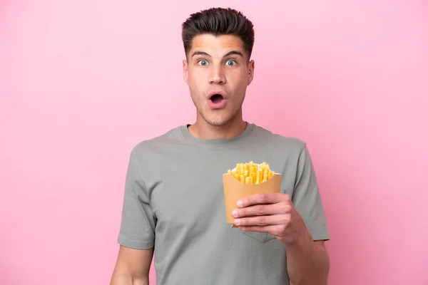 Jonge Kaukasische Man Met Gebakken Chips Geïsoleerd Roze Achtergrond Met — Stockfoto