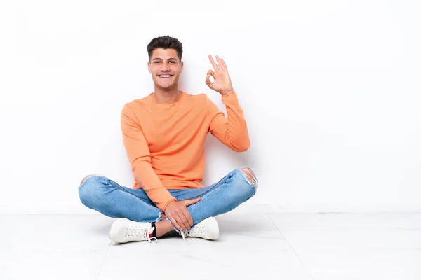 Yerde Oturan Genç Adam Beyaz Arka Planda Izole Edilmiş Parmaklarıyla — Stok fotoğraf