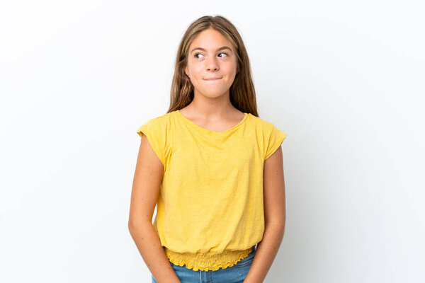 Little caucasian girl isolated on white background having doubts while looking up