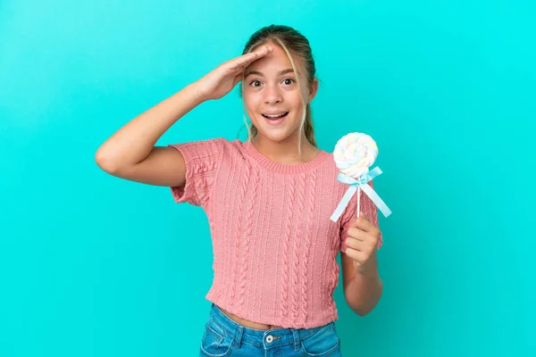 Little Caucasian Girl Holding Lollipop Isolated Blue Background Surprise Expression — Stockfoto