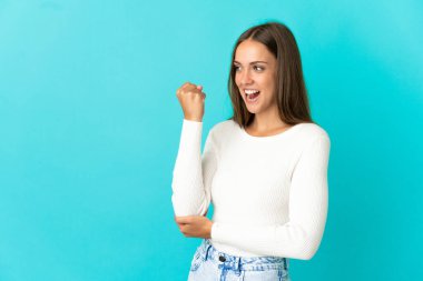 Genç bir kadın mavi arka planda zaferi kutluyor.
