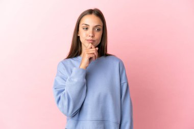 Soyutlanmış pembe arka planı olan genç bir kadın.