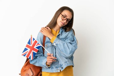 Birleşik Krallık bayrağını taşıyan genç İspanyol bir kadın izole edilmiş beyaz arka planda çabaladığı için omuz ağrısından muzdarip.